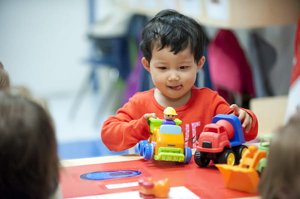 Toddler plays with toys in classroom